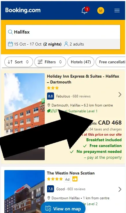 How to use a coupon code at Booking.com step one: An arrow points to a hotel listing on the mobile version of booking.com